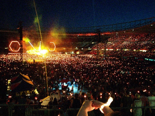 Coldplay concert with red lights and stadion full of red dots